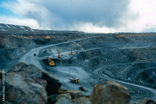 Work of trucks and the excavator in an open pit