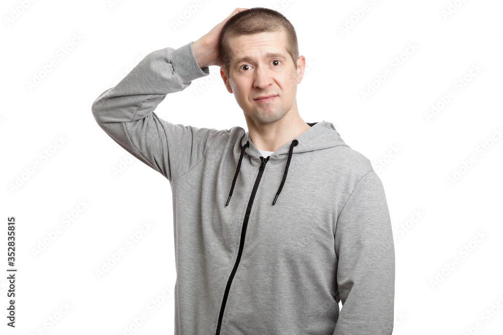 confused insecure man in confusion breeds scratches with his hand on the back of the head. Dressed in sportswear. Isolated confused insecure man in confusion breeds scratches with his hand on the back of the head. Dressed in sportswear. Isolated