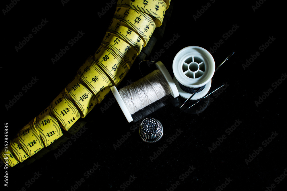 costura-costurera-hilo-aguja-tijeras-metro-coser-textil-negro-amarillo-dedal-cremallera  Stock Photo