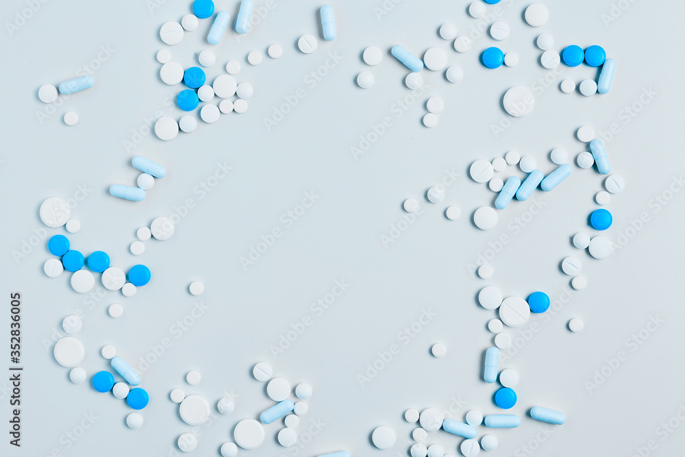 creative medicine compositions. the frame of tablets and capsules, different shapes on a light blue background. vitamins for skin, hair, and nails. flat lay, copy space creative medicine compositions. the frame of tablets and capsules, different shapes on a light blue background. vitamins for skin, hair, and nails. flat lay, copy space