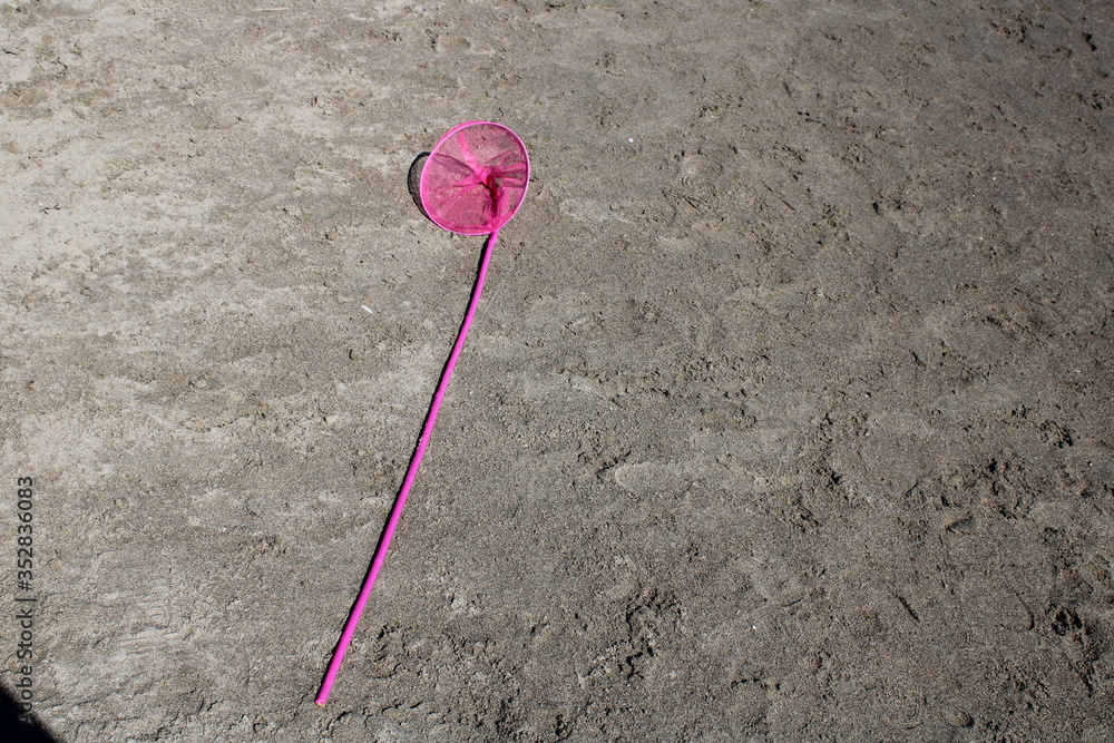 pink butterfly net on beach sand pink butterfly net on beach sand