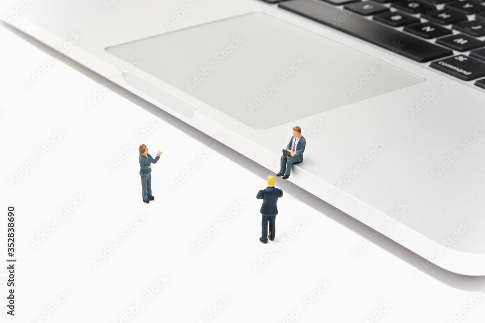 A businesswoman presents to a businessman sitting on a laptop while working on a laptop and another businessman - connectivity and work - Tiny People Working From Home A businesswoman presents to a businessman sitting on a laptop while working on a laptop and another businessman - connectivity and work - Tiny People Working From Home