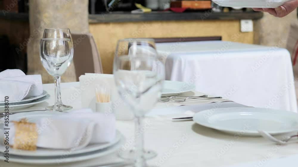 A waiter serves the table in the restaurant A waiter serves the table in the restaurant