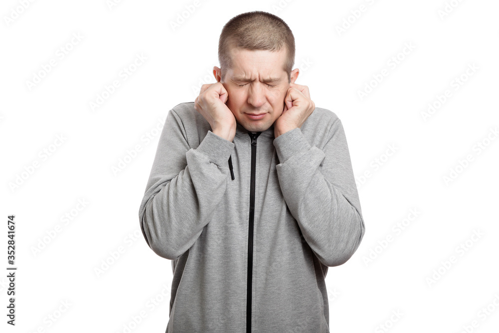 cowardly frightened man covered his ears with his hands, squeezed with fear. Dressed in sportswear. Isolated cowardly frightened man covered his ears with his hands, squeezed with fear. Dressed in sportswear. Isolated