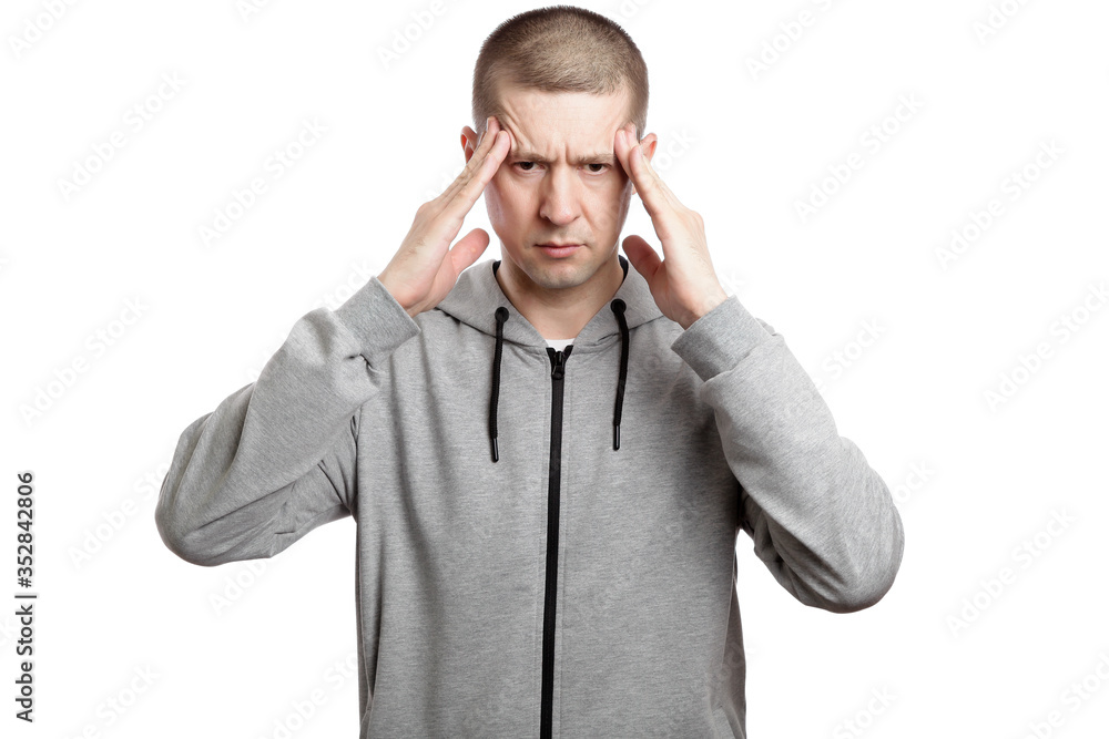 tired brooding man plowed his fingers to the temple of his head, thinking and pondering or a headache. Dressed in sportswear. Isolated tired brooding man plowed his fingers to the temple of his head, thinking and pondering or a headache. Dressed in sportswear. Isolated