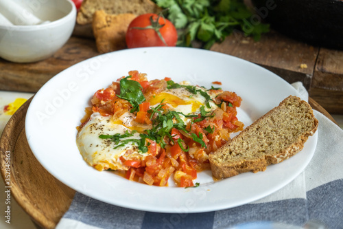 Israel scrambled eggs shakshuka with tomatoes and pepper on a white plate