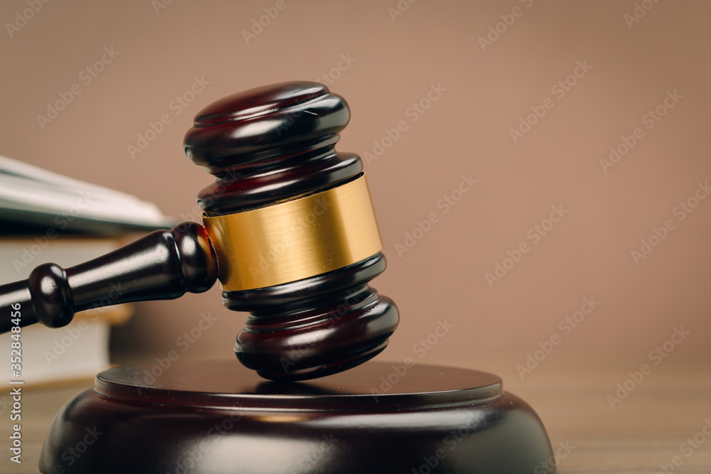 Judge gavel and laws books on a wooden table.