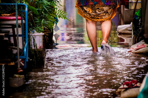 Tela The feet of an Asian woman were walking through the flood.