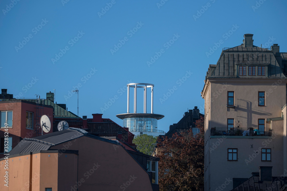 Sunny morning view over old house part of the district of Södermalm, above the waterfront at the bay Riddarfjärden and the tower Söder torn in Stockholm.