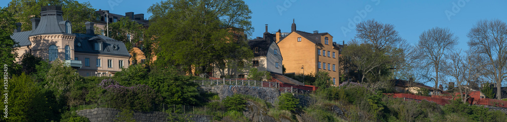 Sunny morning view over old house part of the district of Södermalm, above the waterfront at the bay Riddarfjärden and the sluice part in Stockholm. 