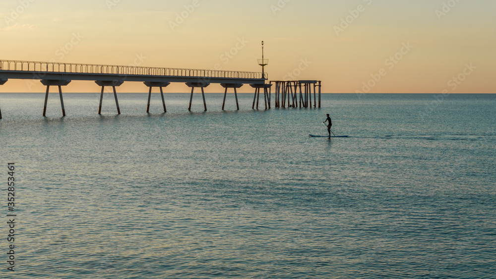 young boy doing paddle surf in the sea