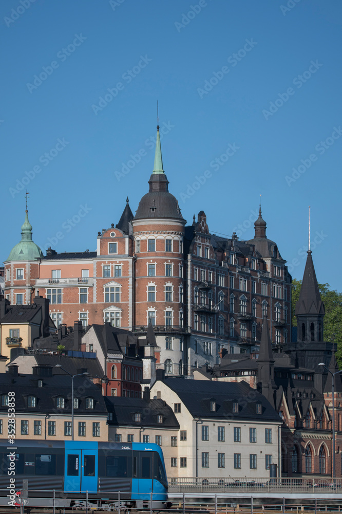 Obraz premium Sunny morning view over old house part of the district of Södermalm, above the waterfront at the bay Riddarfjärden and the sluice part in Stockholm. 