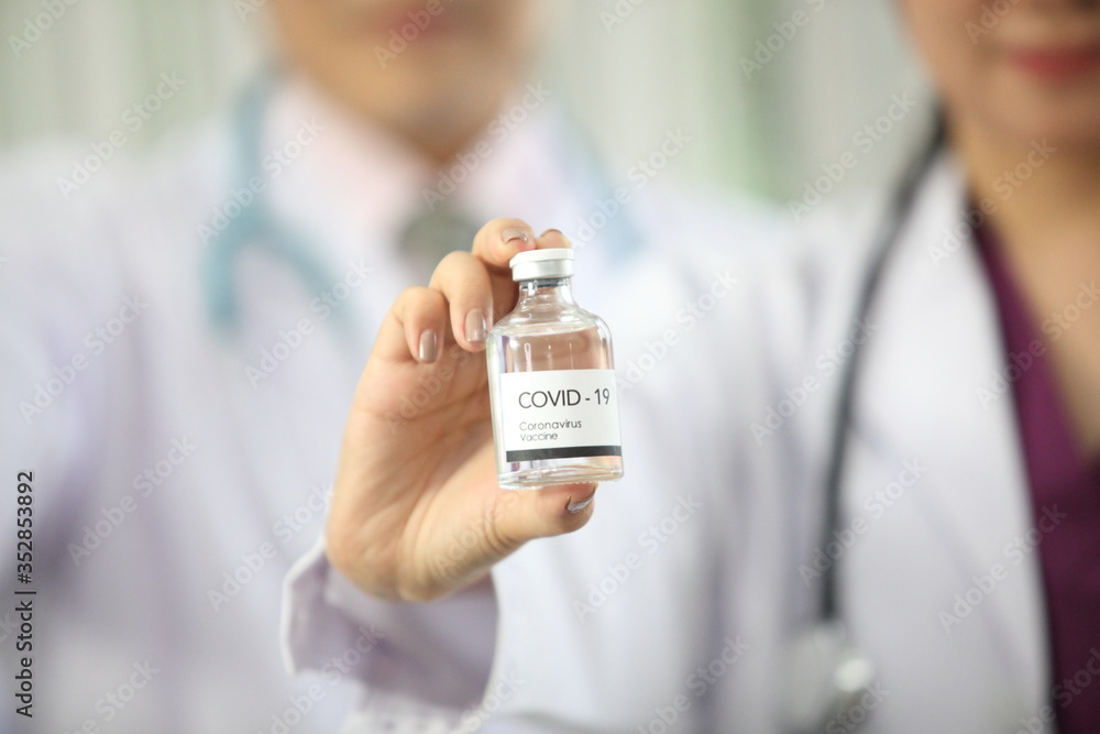 Doctor holding sample covid-19 vaccine vial with medication, closeup. Doctor holding sample covid-19 vaccine vial with medication, closeup.