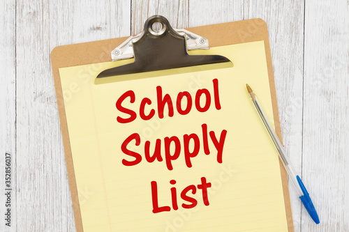 School supply List message on yellow lined paper with a pen on a clipboard photo