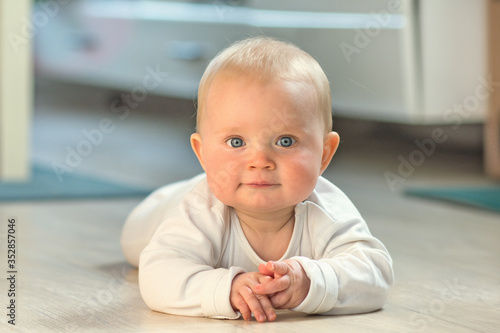 Wallpaper Mural eight month old baby boy lying on the ground and looking at camera Torontodigital.ca