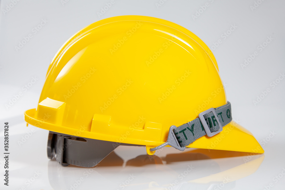 Fototapeta premium Yellow safety helmet on white background. Hard Hat or safety engineer helmet for construction site