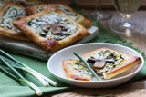 Puffs with cheese, spinach and mushrooms, served with wine and green onions. Rustic style.