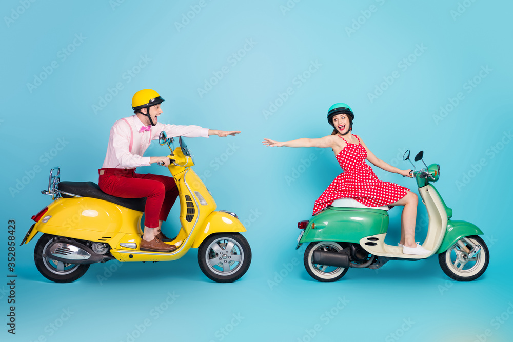 Full length profile side photo crazy friend girl driver guy bike drive chopper try touch hands with her fellow enjoy vacation wear formalwear outfit isolated blue color background Full length profile side photo crazy friend girl driver guy bike drive chopper try touch hands with her fellow enjoy vacation wear formalwear outfit isolated blue color background