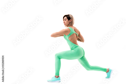 Fototapeta Naklejka Na Ścianę i Meble -  full body portrait of young sporty woman stretching before exercise isolated on white background.