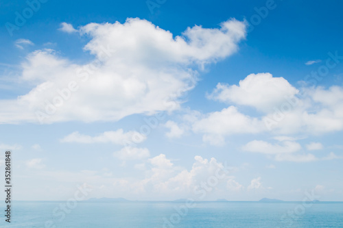 White fluffy clouds and turquoise sea on blue sky