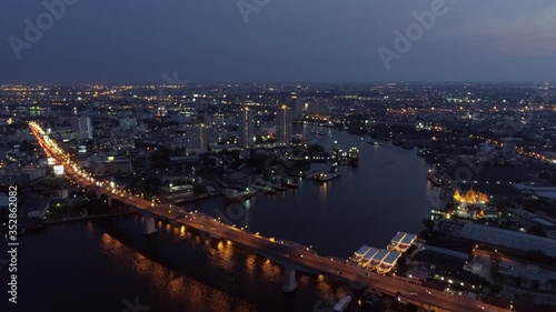 Wallpaper Mural Aerial shot of vehicles on illuminated bridge over river in city at night, drone flying over cityscape against sky - Bangkok, Thailand Torontodigital.ca
