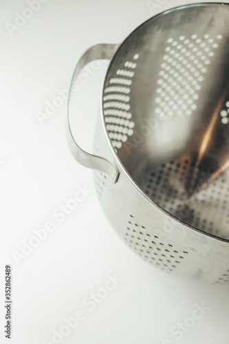 
metal colander for the kitchen on a white background