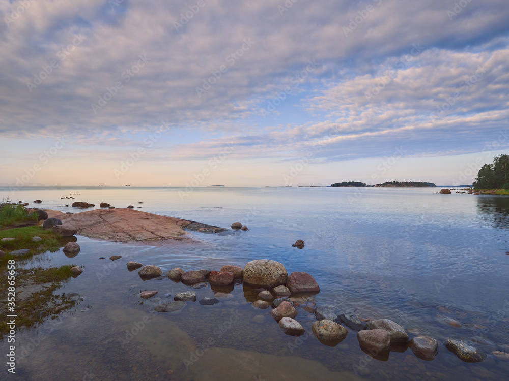 Summer walk along the Gulf of Finland on a wonderful calm morning in Lauttasaari next to the beautiful stones of Finnish nature. Summer walk along the Gulf of Finland on a wonderful calm morning in Lauttasaari next to the beautiful stones of Finnish nature.