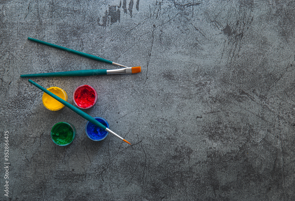 Several dye cubes and art brushes flat lay over rustic backdrop flat lay view with copy space Several dye cubes and art brushes flat lay over rustic backdrop flat lay view with copy space
