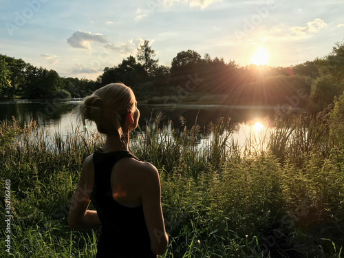 Foto Woman enjoying peaceful moment of beautiful sunset by  lake