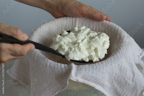Φωτογραφία Woman hands putting mess of fermented cheese or cottage cheese or greek yogurt o