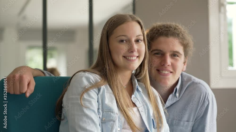 young couple smiling facing camera young couple smiling facing camera