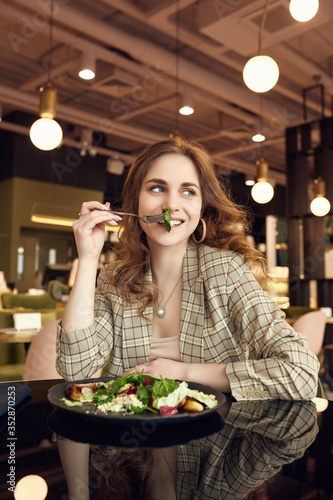 Young beautiful smiling woman eating healthy food