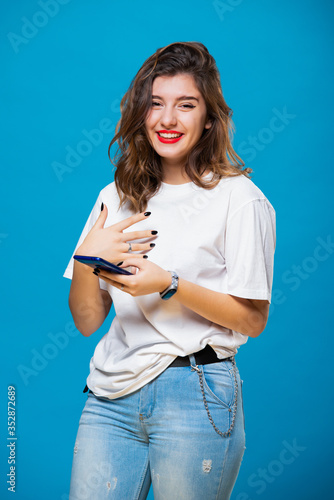Foto Smiling girl with a mobile phone in her hands