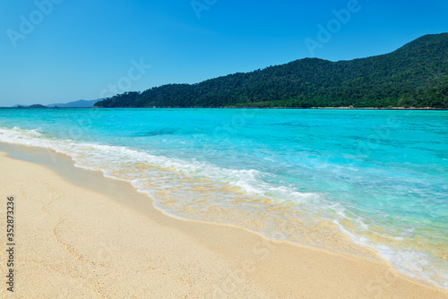 Turquoise clear sea and white sand beach on tropical island