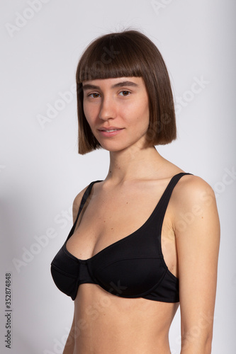 3/4 portrait of sweet girl in black bra and short hairstyle isolated on white © veles_studio