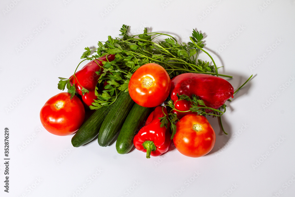 Vegetables tomatoes, cucumbers, bell peppers and parsley on a light background. Vegetables tomatoes, cucumbers, bell peppers and parsley on a light background.