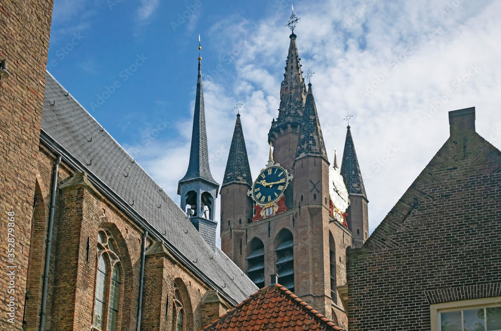 Fototapeta premium Detail of medieval skyline with towers of Old Church in historic city center of Delft, Netherlands. Travel or tourist abstract cityscape. 