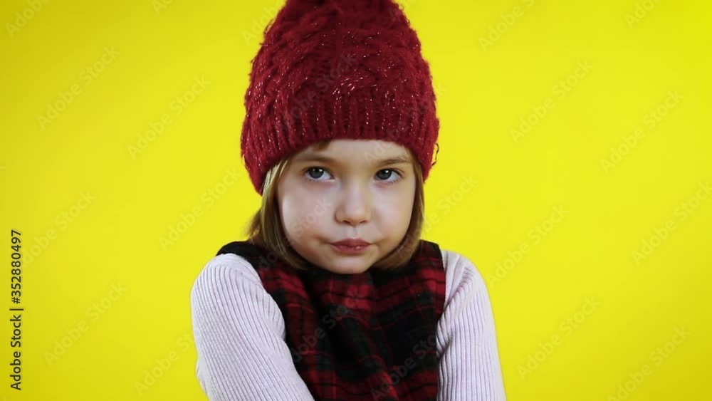 Embarrassed cute little girl it hat on yellow background. Embarrassed cute little girl it hat on yellow background.