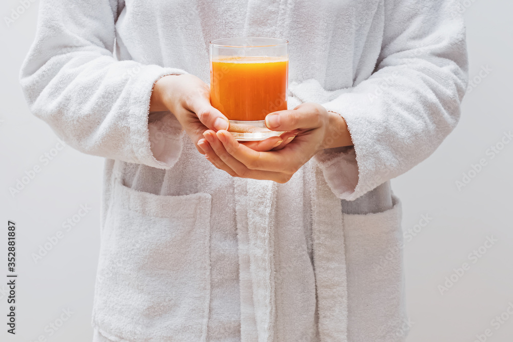 Close-up shot of woman's hands holding a glass of fresh citrus juice Close-up shot of woman's hands holding a glass of fresh citrus juice