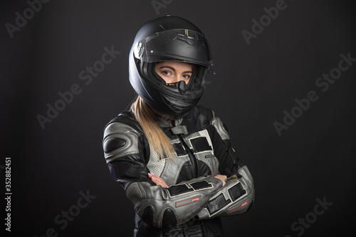 Girl in a motorcycle outfit on a black background