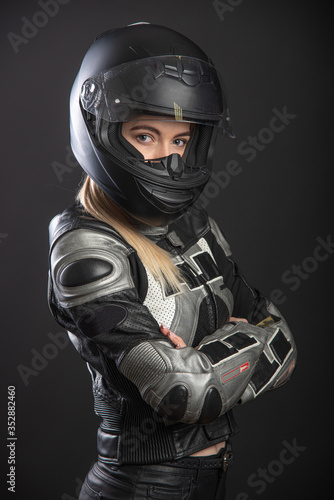 Girl in a motorcycle outfit on a black background