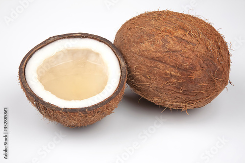 cut fresh coconut with real coconut milk on a white background. vitamin fruits. healthy food