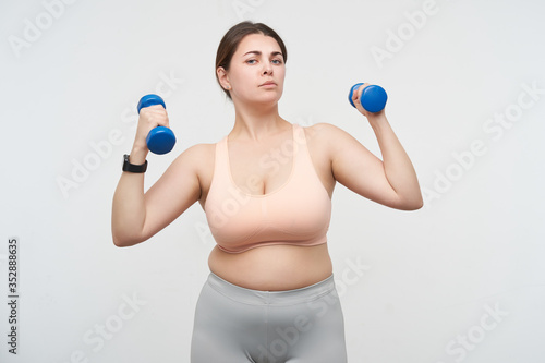 Obraz na płótnie Indoor photo of young brunette chubby lady with casual hairstyle looking serious