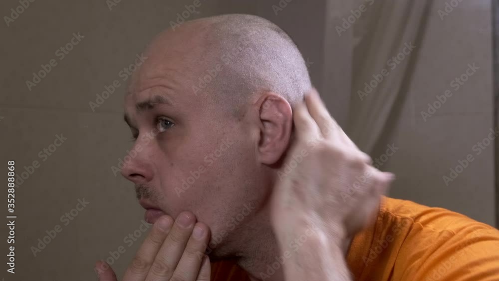 A man looks in the mirror as he cut his hair. A man looks in the mirror as he cut his hair.