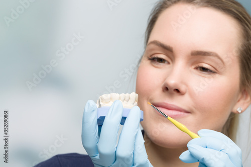 close up of female dentist working on dental imprint with artificial dentition in detal laboratory