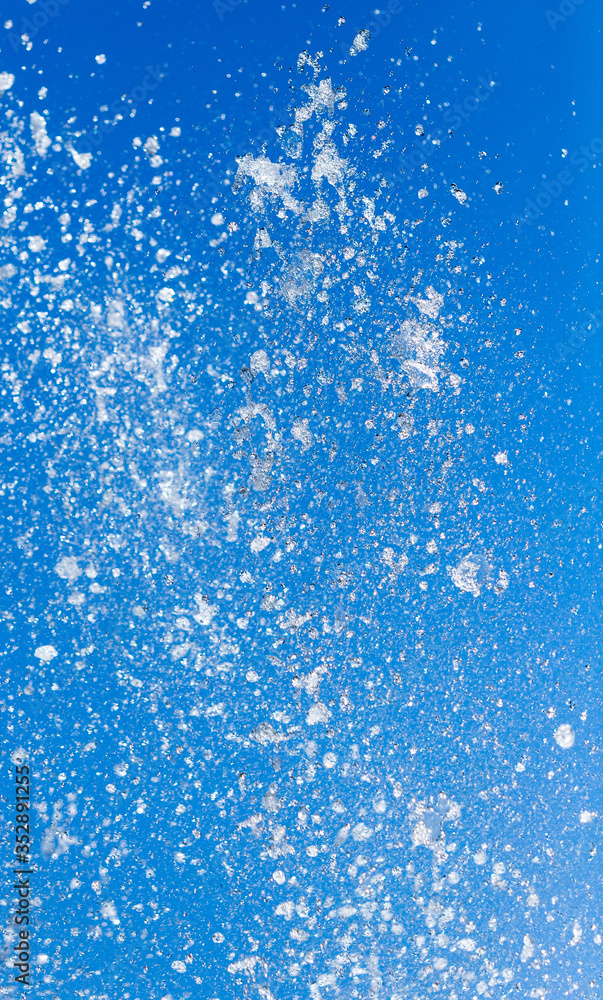 Splashing water from a fountain on a background of blue sky Splashing water from a fountain on a background of blue sky