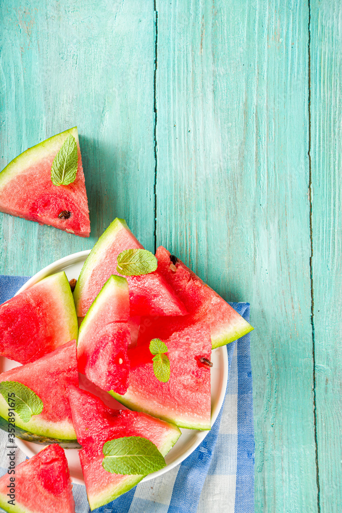 Watermelon slices on light blue wooden background
