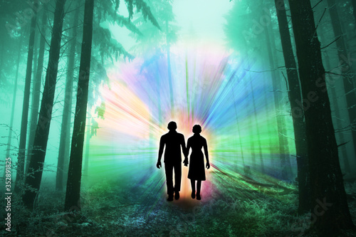 black silhouettes of man and woman with luminous rays of energy in a dark forest Fototapete