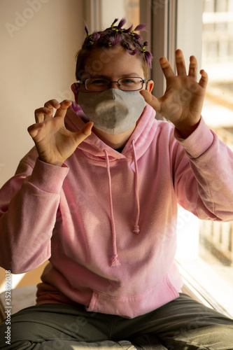 Teenager girl with an unusual hairstyle in a protective mask. photo