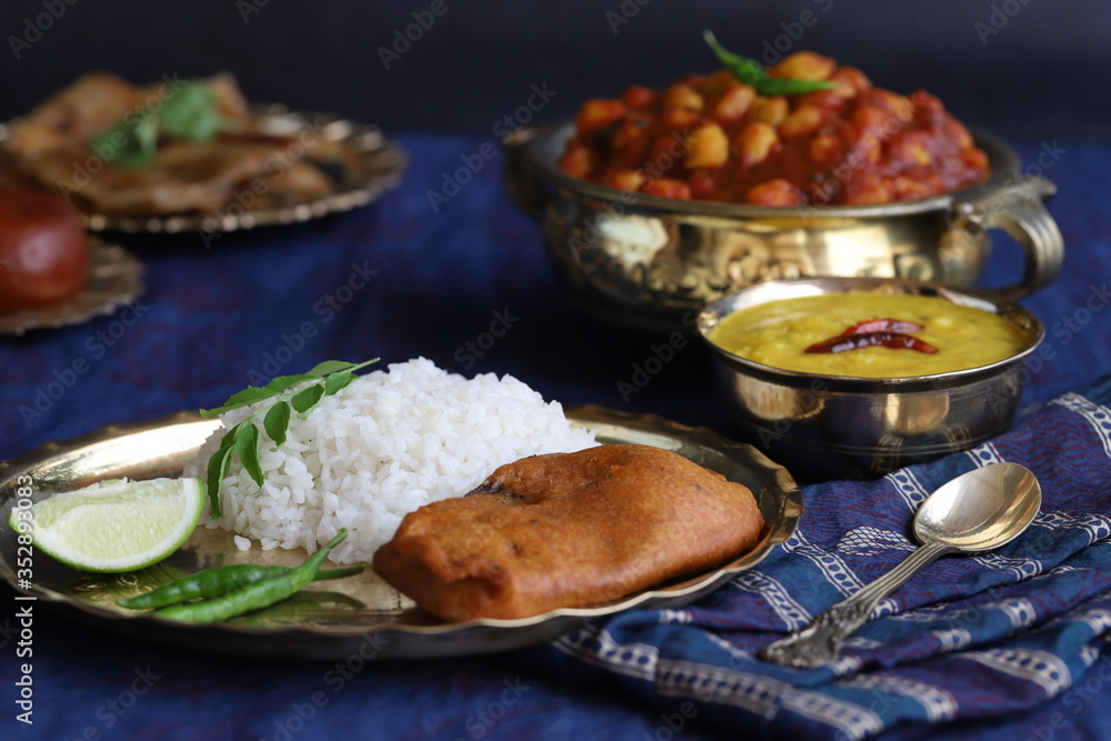 dishes of national Indian cuisine on a dark blue background. traditional Indian home-cooked dinner. rice, dal, sabji, aloo parantha, gulabjamun, masala